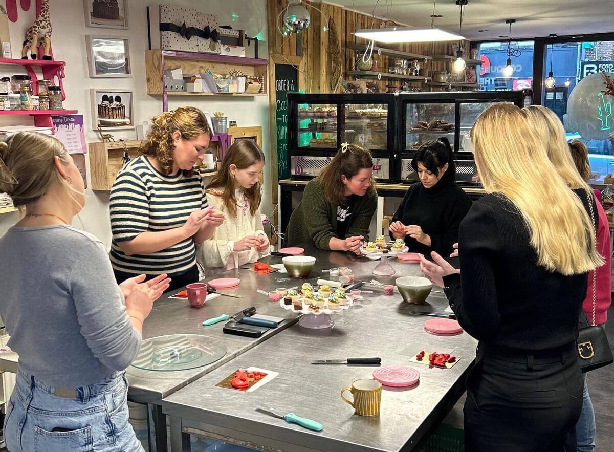 Bakkersworkshop bij Bake My Day Groningen waar deelnemers leren taarten en cupcakes decoreren in de winkel.